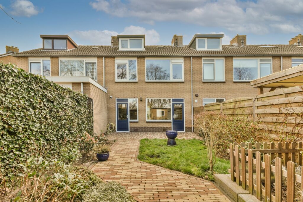 Rear of a brick terraced house with a lawn and a brick path