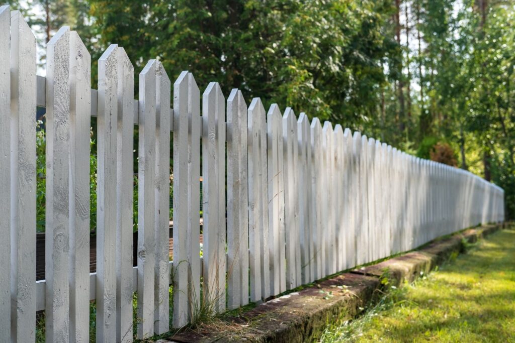 Garden with a lawn and a white picket fence